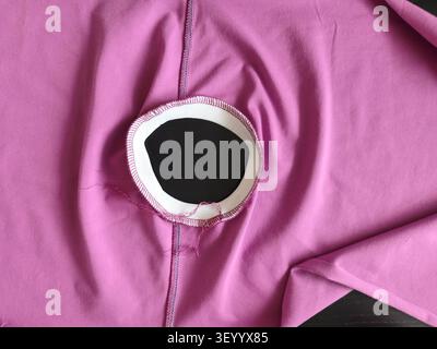 Round neck construction of a knitwear clothing during sewing production, professional serger seam on garment fabric. Industrial, Arts Stock Photo