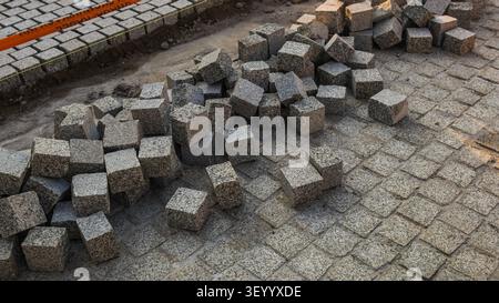 New rough grey granite cobblestone cubes during city street renovation Stock Photo