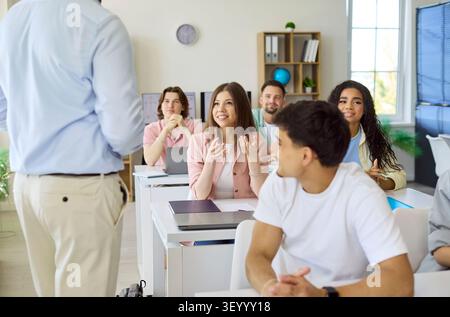 Engaged College Students Asking Teacher Questions During Active Classroom Lesson Stock Photo