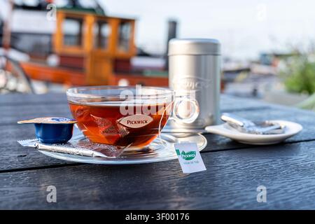 cup of Pickwick black tea served in a transparent glass cup on a clear saucer Stock Photo