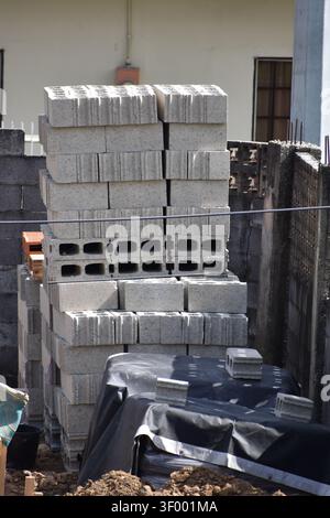 A stack of hollow concrete wall blocks, also known as cinder blocks, stacked on pallets for construction use. Stock Photo