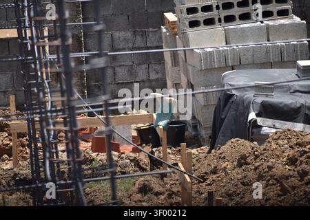 A stack of hollow concrete wall blocks, also known as cinder blocks, stacked on pallets for construction use. Stock Photo