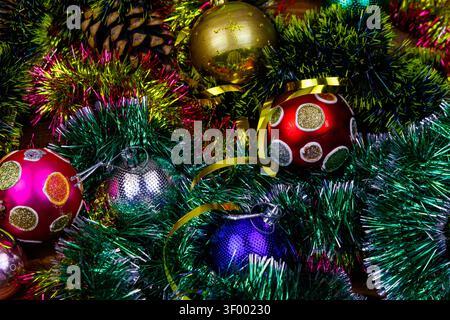 Christmas composition with Christmas baubles and multicolored tinsel. Christmas balls in bright tinsel close-up Stock Photo