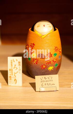 Kyoto, Japan - April 12th, 2026: Beautiful Kokeshi japanese hand made wood dool Irodori Momiji model wih colorful maple leaf motifs Stock Photo