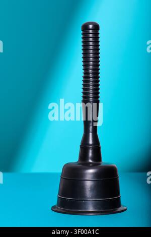 Close-up of a rubber plunger on a blue table. Plumbing and maintenance works in home. Problems and solutions chore. Stock Photo