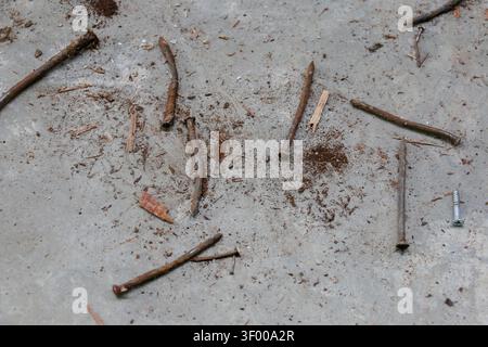 Rusty Bent Nails on Concrete Floor Showing Contrast Between Old and New Construction Materials Stock Photo