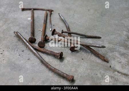 Rusty Bent Nails on Concrete Floor Showing Contrast Between Old and New Construction Materials Stock Photo