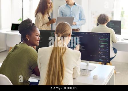 Diverse developers collaborating on code in modern office teamwork and technology Stock Photo