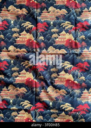 Traditional Japanese fabric print with classic pagoda and mountain landscape pattern in rich red, gold and navy blue on dark blue background Stock Photo