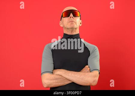 sporty bald man standing with arms folded, looking up Stock Photo