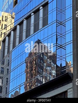A reflection of the famous Palmer House Hotel in Chicago is displayed on a building across the street. Blue reflective mirror-like image with distorti Stock Photo