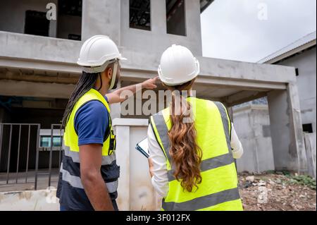 Civil construction managers inspecting unfinished residential building project with civil engineer, checking house construction project, Concept of pr Stock Photo