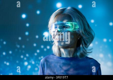 Portrait of a futuristic senior asian woman wearing a glowing augmented reality visor, lit by blue neon and floating particles, suggesting innovation, Stock Photo