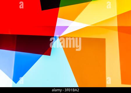Vibrant abstract background of overlapping translucent geometric panels in red, orange, yellow, blue, and cyan, creating sharp angles, gradients, and Stock Photo