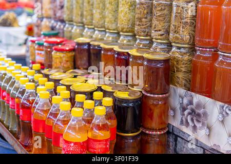 Various types of homemade pickles and jams displayed in glass jars for sale at the market. Food Stock Photo
