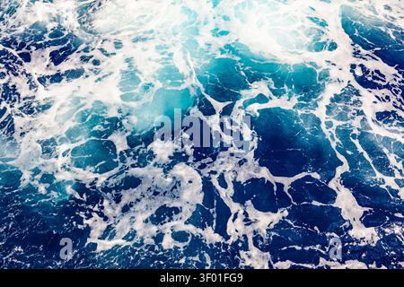 Top down view of deep blue sea water surface with dynamic white foam trail ripples and liquid abstract texture Stock Photo