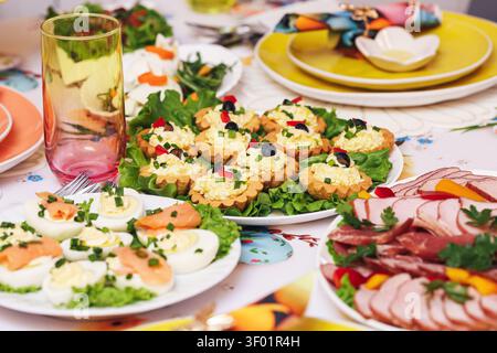 Assorted party appetizers with eggs cheese vegetables and cold cuts on festive table. Finger food background for buffet catering celebration. Stock Photo