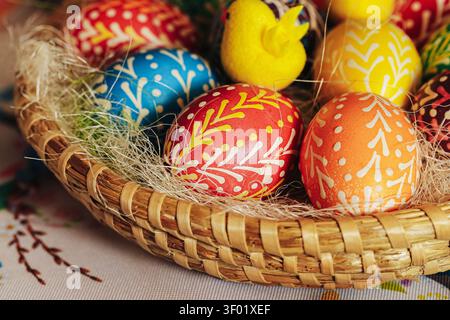Colorful hand painted Easter eggs arranged in traditional wicker basket. Holiday background for spring celebration decoration family and festive. Stock Photo