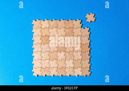 Unfinished business puzzle connecting missing piece on blue background Stock Photo