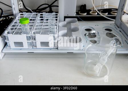 Laboratory sample preparation setup with test tubes in racks, beaker on a clean laboratory bench. Scientific analysis, analytical chemistry, environme Stock Photo