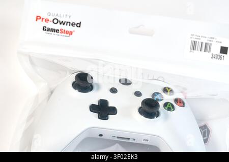 DALLAS, TX, USA - FEBRUARY 16, 2024: A close-up image of a GameStop labeled pre-owned Xbox controller inside a clear plastic package. The packaging pr Stock Photo