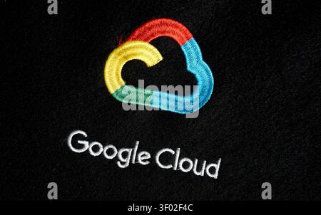 DALLAS, TX, USA - FEBRUARY 16, 2024: A detailed close-up of the Google Cloud logo embroidered on a black fabric. The logo showcases a stylized cloud s Stock Photo