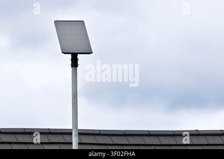 Close-up of an integrated solar powered LED street light with built-in photovoltaic panel installed on a modern residential development beneath a clou Stock Photo