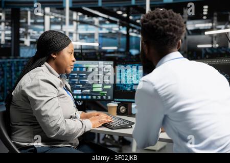 Server facility engineering team applying AI neural network models technology. Professional and coworker in data center working with AI programming tools to set up specialized hardware. Stock Photo