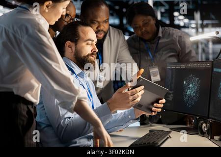 Team of software developers working with workstation in server environment, analyzing data. Stock Photo