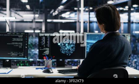 Server room system administrators working with machine learning models on computer to review data sets. Stock Photo