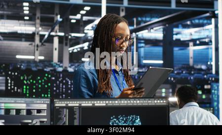 Engineer uses a computer workstation in a server farm to categorize unstructured data with node tree systems. Stock Photo