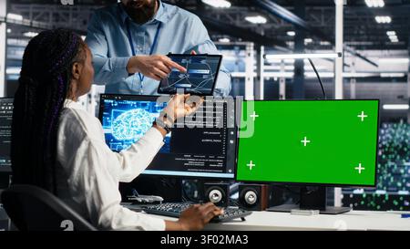 IT colleagues collaborate in a data center while reviewing AI diagnostics and infrastructure performance. Stock Photo