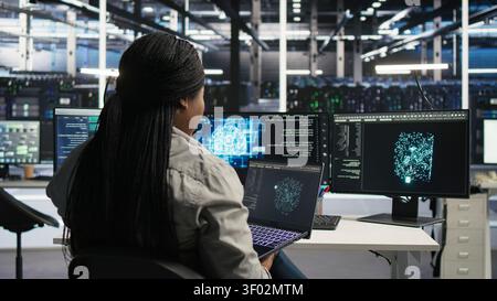 Data center IT expert working with notebook computer to apply AI technology minimizing system downtime. Stock Photo