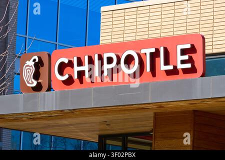 DALLAS, TX, USA - FEBRUARY 16, 2024: A Chipotle Mexican Grill sign is prominently displayed on the exterior of a modern commercial building in Dallas. Stock Photo