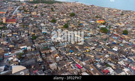 Aerial view of the dense urban landscape of Teshie with closely packed rooftops and narrow streets stretching towards the coastline in Accra, Greater Stock Photo