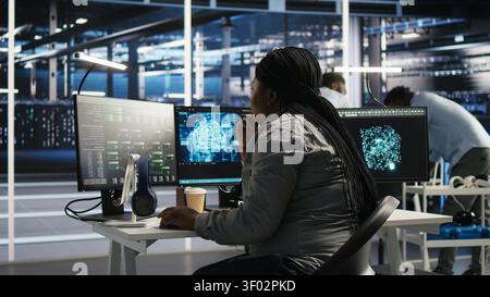 Server facility software engineer applying AI ML models to set up hardware. IT professional works on AI programming tools in server environment, optimizing system. Stock Photo