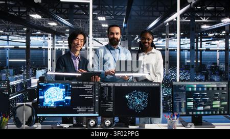 Engineers program on a computer workstation in a data center with generative AI assistance. Stock Photo