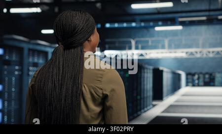 Data center technician uses a tablet in a server room to develop disaster recovery plans and reduce downtime. Stock Photo