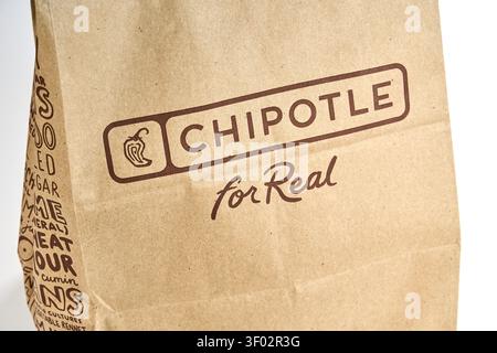 DALLAS, TX, USA - FEBRUARY 16, 2024: A Chipotle branded paper bag featuring the text 'for Real' photographed in Dallas. The bag is brown with the Chip Stock Photo