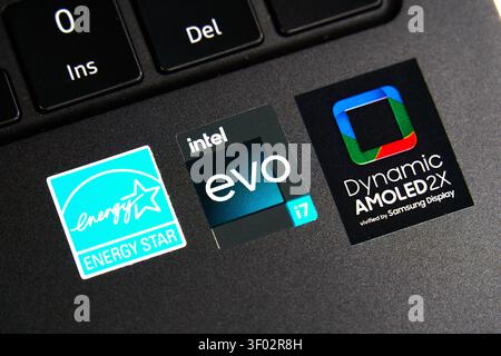 DALLAS, TX, USA - FEBRUARY 16, 2024: A close-up photograph of a laptop keyboard featuring three distinct stickers. The first sticker is the Energy Sta Stock Photo