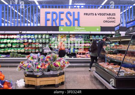 CARROLLTON, TX, USA - FEBRUARY 24, 2024: Shoppers browse the fresh produce section at a supermarket, showcasing a variety of fruits and vegetables wit Stock Photo
