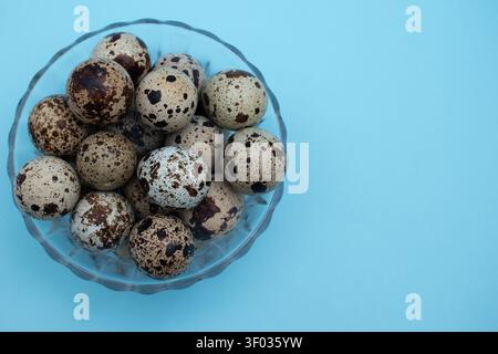 Fresh quail eggs on blue background in various minimalist food compositions Stock Photo