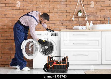 Technician repairing front load washing machine indoors Stock Photo