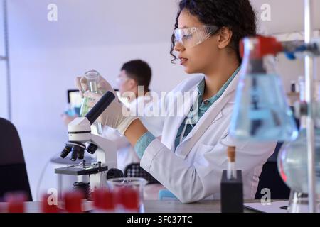 Female African-American chemist working at table in laboratory Stock Photo