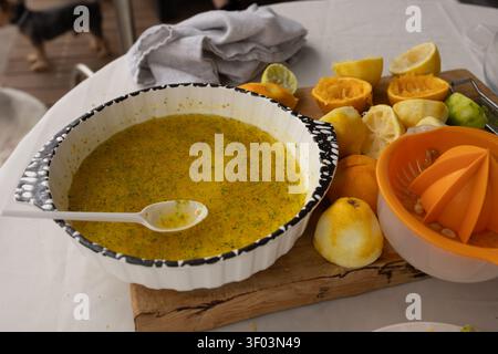 A close-up of the process of preparing citrus juice on a kitchen counter, featuring a juicer, fresh lemons and oranges, and vibrant colors. This scene highlights the healthy lifestyle. Stock Photo