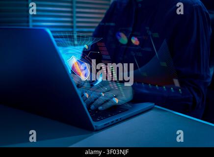 Cybersecurity analyst monitoring AI security analytics and data protection system on laptop dashboard. Cyber defense, network security, threat detecti Stock Photo