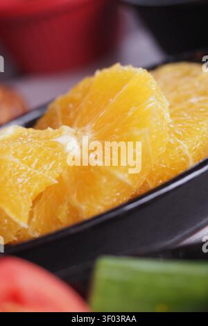 Fresh orange slices on a black plate ready for serving Stock Photo