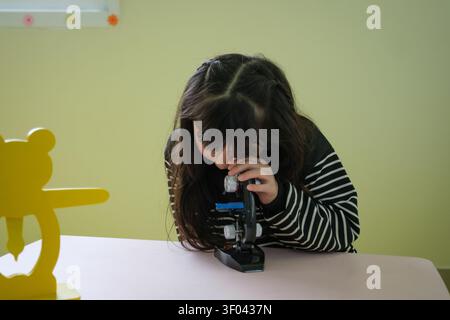 The students are having fun looking through the microscope. Stock Photo
