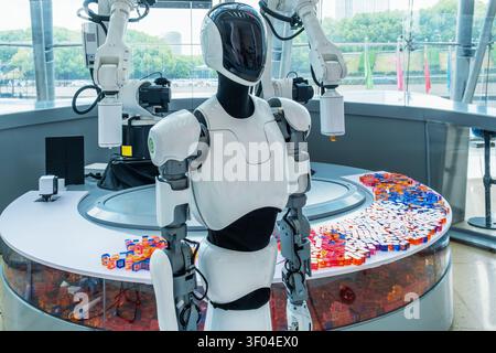 Humanoid robot with robotic arms performing automated demonstration in modern technology exhibition. Modern artificial intelligence, advanced Stock Photo