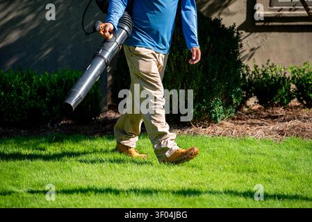 Man using leaf blower to clean a yard Stock Photo